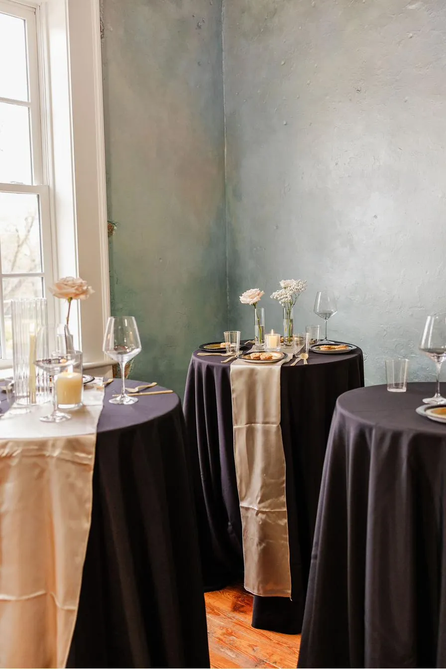 Cocktail tables at Brick and Beam dressed in navy and champagne with single stem roses