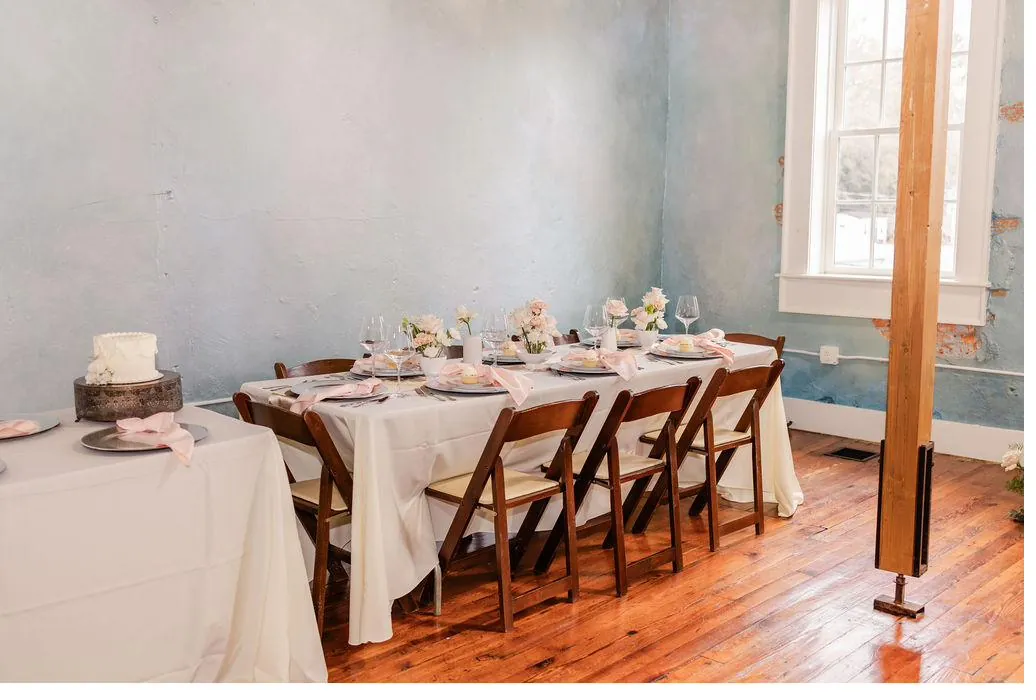 Brick and Beam Events event room with blush floral tablescape and natural window light